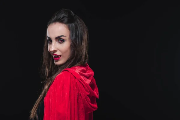 Sexy vampiro mujer en rojo capa aislado en negro - foto de stock