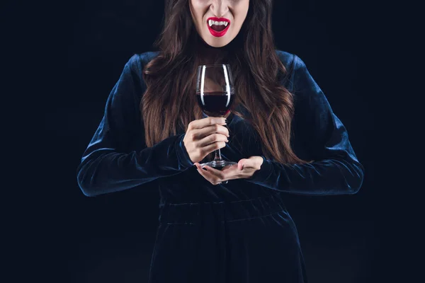 Vue recadrée de vampire tenant verre à vin avec du sang isolé sur noir — Photo de stock