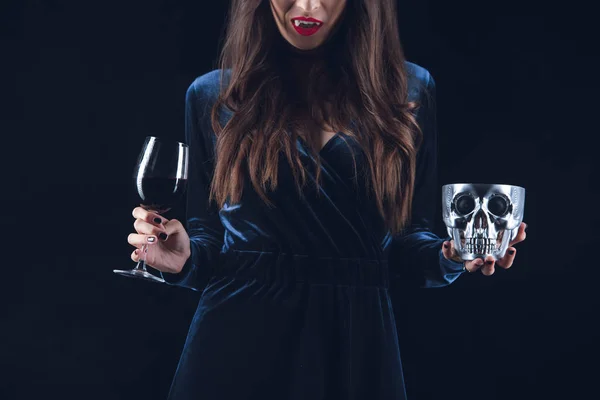Vista ritagliata di donna vampiro con teschio e bicchiere da vino con sangue isolato su nero — Foto stock
