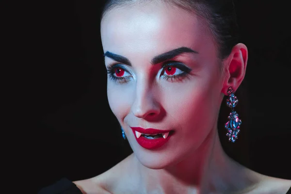 Femme vampire sexy montrant ses dents isolées sur noir — Photo de stock