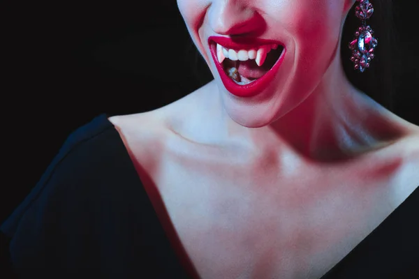 Vista recortada de vampiro mostrando sus dientes aislados en negro - foto de stock