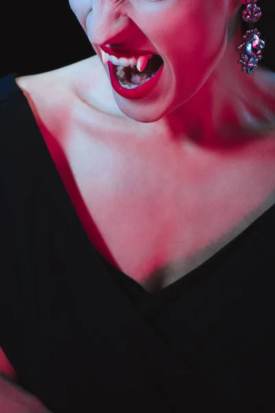 Vista cortada de vampiro mostrando suas presas no fundo escuro — Fotografia de Stock