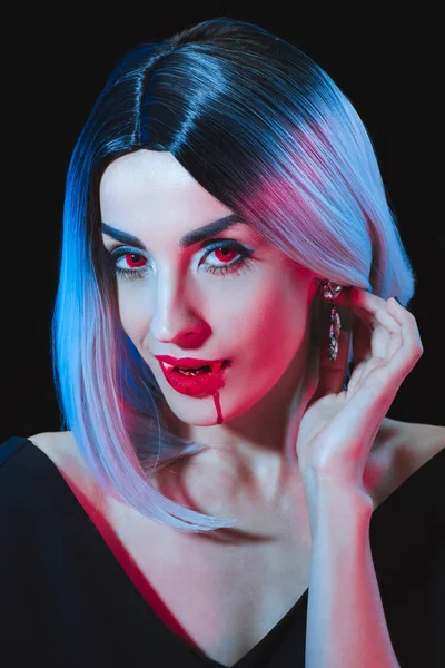 Mujer vampiro sexy mirando a la cámara aislada en negro - foto de stock