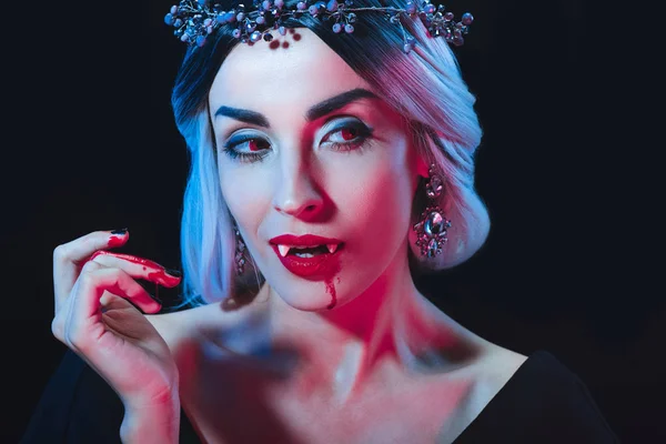 Sexy vampire woman with blood on face looking away isolated on black — Stock Photo