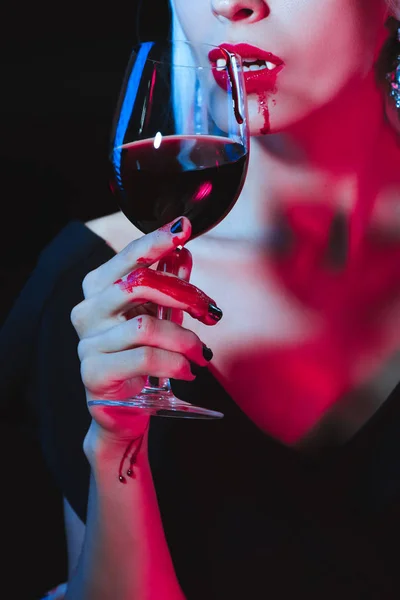 Abgeschnittene Ansicht eines Vampirs, der Blut aus einem Weinglas trinkt, isoliert auf schwarz — Stockfoto