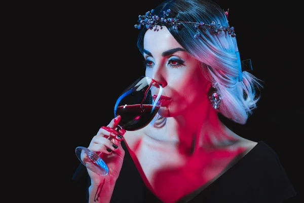 Sexy vampiro bere sangue da bicchiere di vino isolato su nero — Foto stock
