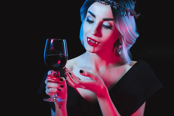 Sexy vampiro donna in possesso di bicchiere da vino con sangue isolato su nero — Foto stock