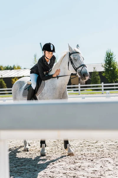 Attraente femmina equitazione equestre e palming purosangue cavallo a cavallo club — Foto stock