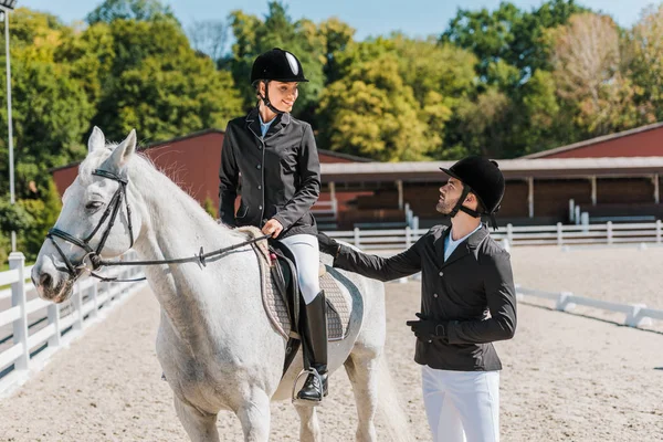 Female and male equestrians looking at each other at horse club — Stock Photo