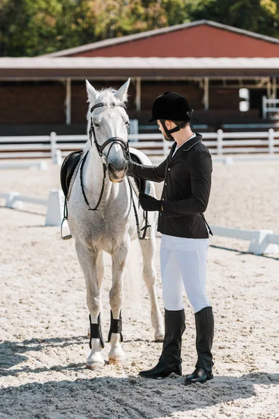 Handsome male equestrian fixing horse halter at horse club — Stock Photo