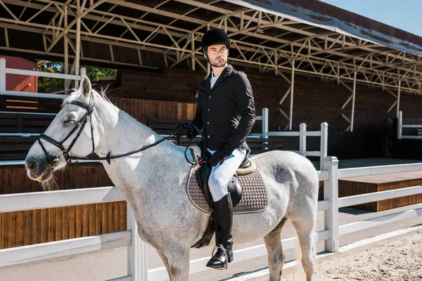 Stattliche männliche Reiterin reitet Schimmel im Pferdeclub — Stockfoto