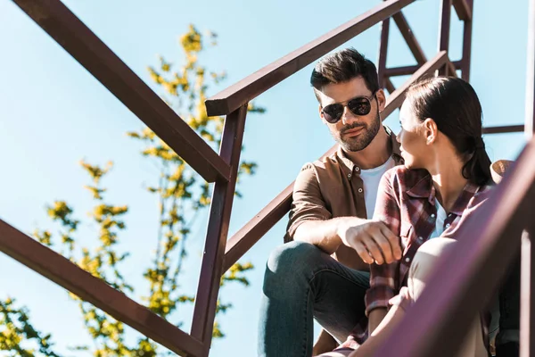 Friends in casual clothes sitting on staircase at ranch — Stock Photo