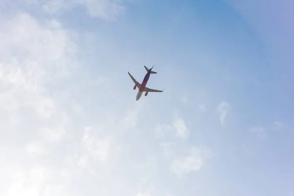 Vista de ángulo bajo del avión que vuela en cielo azul nublado - foto de stock