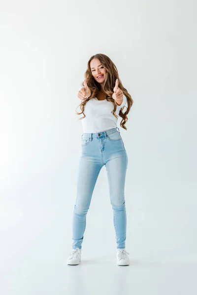 Menina sorrindo atraente mostrando polegares para cima, isolado em branco — Fotografia de Stock