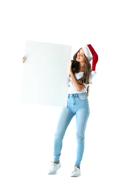 Attraente ragazza in cappello di Babbo Natale in possesso di cartello bianco, isolato su bianco — Foto stock