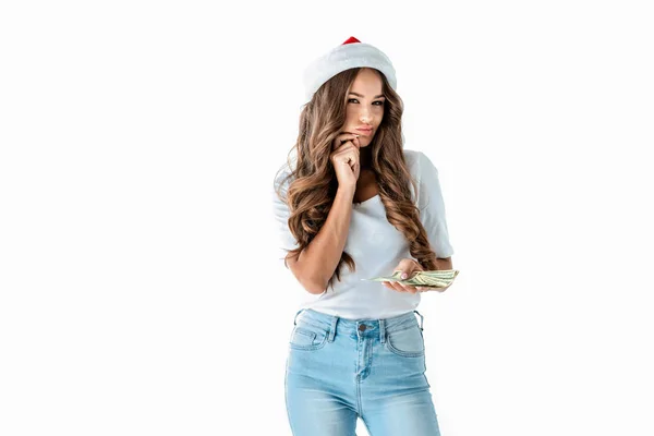 Attraktives schlaues Mädchen mit Weihnachtsmütze, das Dollarnoten hält, isoliert auf weißem Grund — Stockfoto