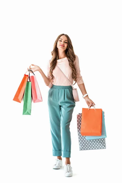 Привлекательная счастливая девушка позирует с красочными пакетами покупок, изолированные на белом — стоковое фото