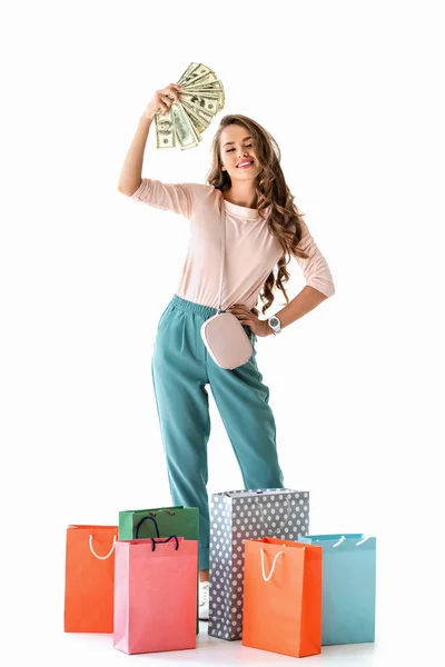 Chica feliz sosteniendo dólares y bolsas de compras, aislado en blanco - foto de stock