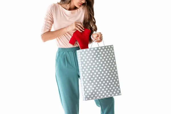Vista cortada de menina com saco de compras e sapato vermelho, isolado em branco — Fotografia de Stock