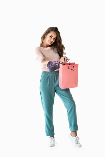 Hermosa chica alegre con bolsa de compras y caja de regalo en forma de corazón, aislado en blanco - foto de stock