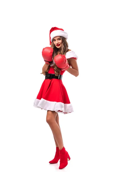 Bella ragazza sorridente posa in costume da Babbo Natale e guanti da boxe, isolato su bianco — Foto stock