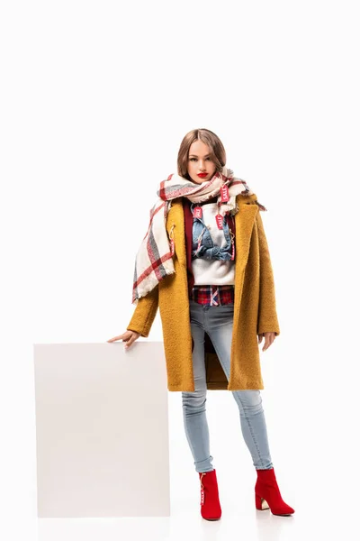 Attractive girl in autumn outfit with sale tags holding blank board, isolated on white — Stock Photo