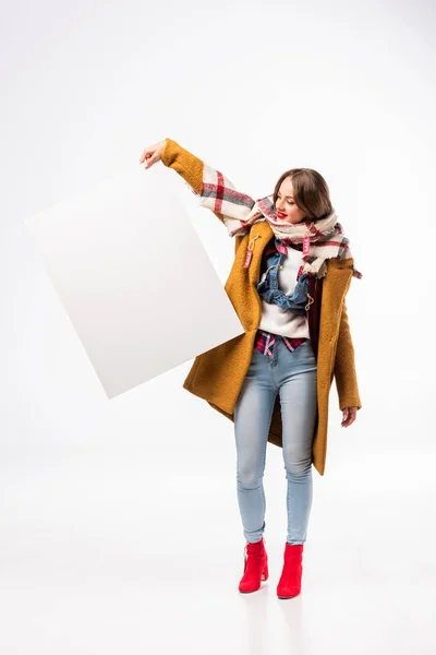 Girl in autumn outfit with sale tags holding empty board, isolated on white — Stock Photo
