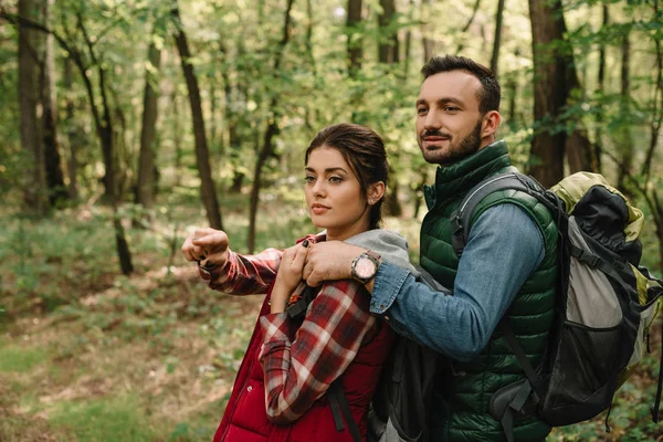 Man hugging woman while hiking in forest together — Stock Photo