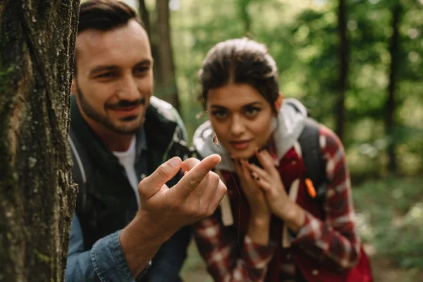 Selective focus of couple of travelers looking at spider on net in forest — Stock Photo