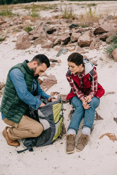 Pareja de viajeros con mochilas en la playa de arena - foto de stock