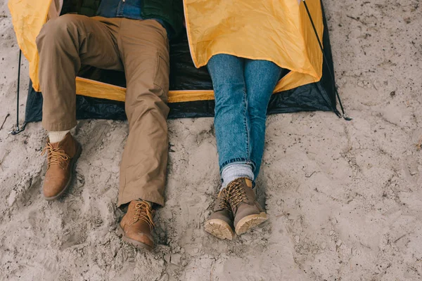 Plan recadré de couple reposant dans une tente de camping sur une plage de sable fin — Photo de stock
