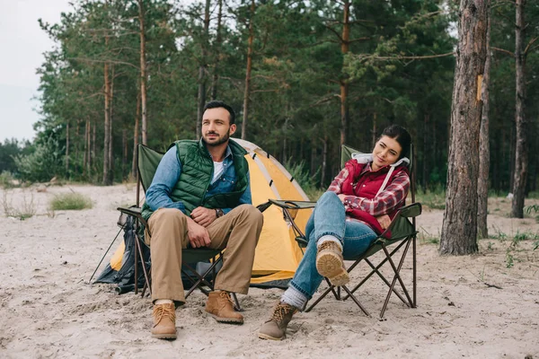 Couple se reposant sur des chaises tout en ayant camping — Photo de stock