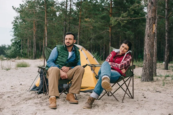 Couple resting on chairs while having camping — Stock Photo