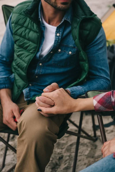 Teilansicht von Mann und Frau, die sich beim gemeinsamen Zelten an den Händen halten — Stockfoto