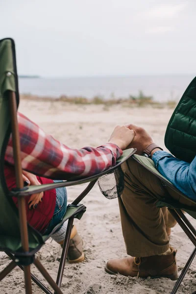 Vue partielle de l'homme et de la femme se tenant la main tout en profitant du camping ensemble — Photo de stock