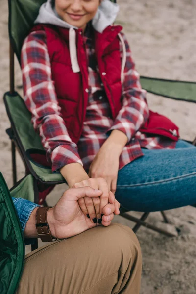 Teilansicht von Mann und Frau, die sich beim gemeinsamen Zelten an den Händen halten — Stockfoto