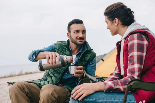 Casal beber chá quente durante o acampamento — Fotografia de Stock