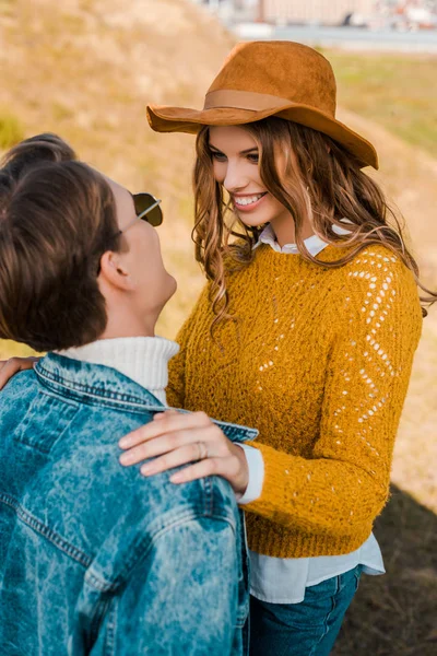 Hermosa novia sonriendo a novio en rural prado - foto de stock