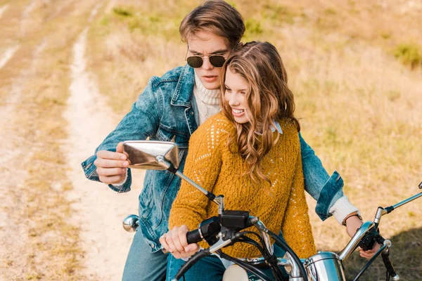 Schönes Paar blickt auf Spiegel eines Retro-Motorrads — Stockfoto