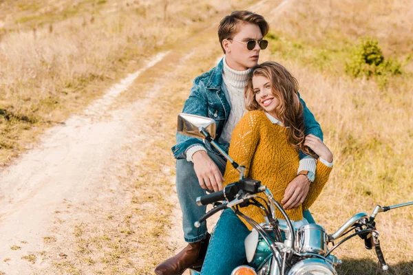Красивый парень обнимает девушку и сидит на мотоцикле — стоковое фото