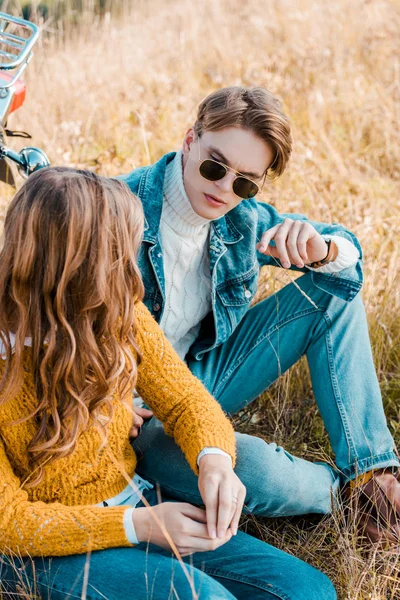 Pareja joven mirándose en el prado rural - foto de stock