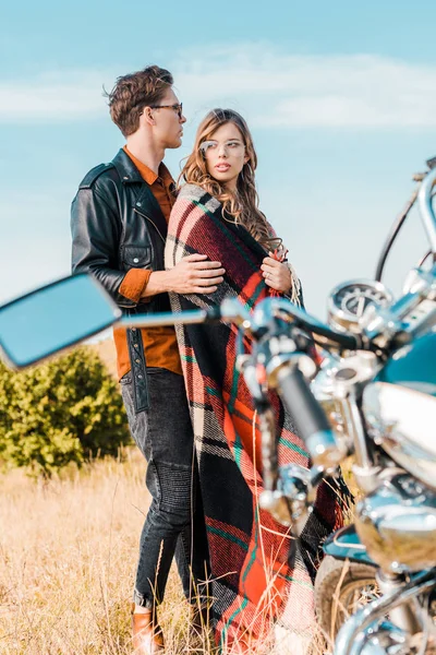 Молода пара в окулярах стоїть біля ретро мотоцикла — стокове фото