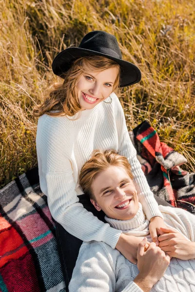 Heureux jeune couple regardant caméra sur prairie rurale — Photo de stock