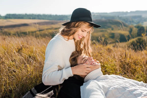 Jeune copine toucher les joues du petit ami sur la prairie — Photo de stock