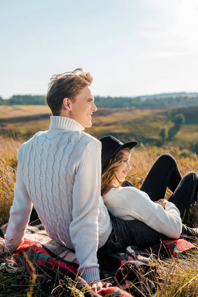 Jovem casal olhando para longe no prado rural — Fotografia de Stock