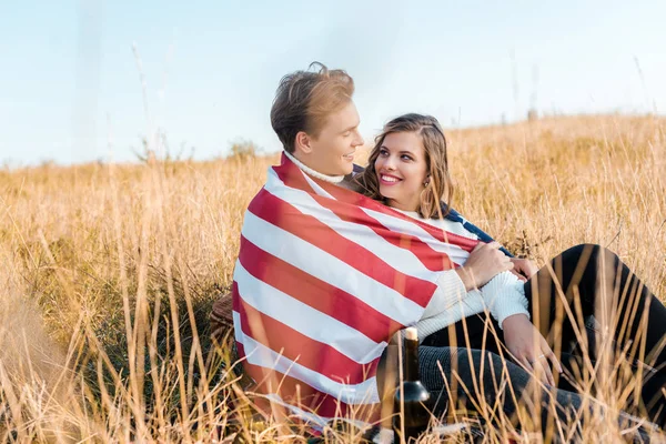 Happy couple with american flag resting on grass, independence day concept — Stock Photo