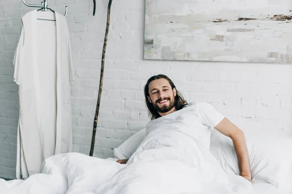 Усміхаючись Ісуса, прокинувшись в спальні під час ранкової час вдома — стокове фото