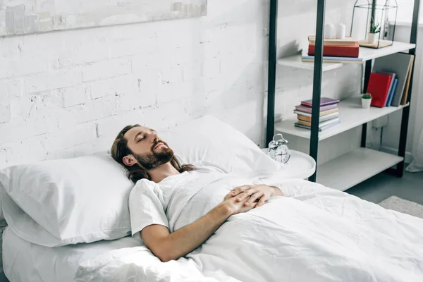 Beau jeune homme barbu se réveillant dans la chambre à coucher à la maison — Photo de stock