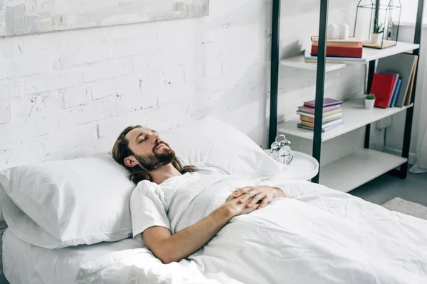 Guapo joven barbudo despertando en el dormitorio en casa — Stock Photo