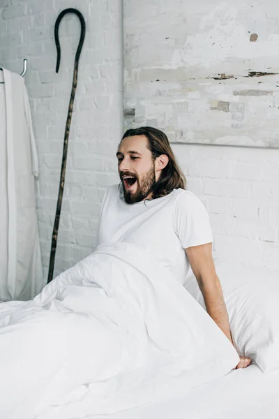 Beau Jésus bâillant au lit le matin à la maison — Photo de stock